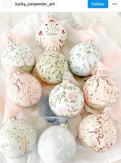 a bunch of ornaments sitting on top of a white cloth covered table next to each other