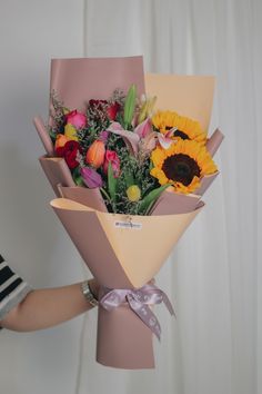 a person holding a bouquet of flowers in their hand