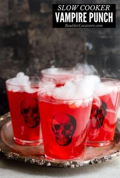 three glasses filled with red liquid on top of a plate