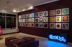 a living room filled with lots of furniture and pictures on the wall next to a red chair