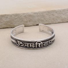 About item Item :-  Kriya Bangles Kada Ring size :- Chose from variation (Custom size accepted) Material  :- German Silver, Brass Title:-Om Namah Shivay Sacred Bracelets, Mantra Bracelet "Aum Namah Shivay "Open Face Cuff Bangle, Sacred Bracelets for Spiritual Bliss, Yoga Gifts, God Shiva bangles, Om Spiritual Jewelry, Valentine's day gift, Christmas day gift Description:- We accept all types of custom & personalized order. Please send us a message if you are interested in a custom creation. What Spiritual Friendship Cuff Bangle Bracelet, Spiritual Friendship Cuff Bracelet, Adjustable Symbolic Cuff Bracelet, Symbolic Bangle Bracelet For Meditation, Adjustable Symbolic Bangle, Personalized Spiritual Bangle Bracelet, Spiritual Nickel Free Bracelet For Festivals, Spiritual Nickel-free Bracelets For Festivals, Symbolic Bangle Bracelets For Festivals