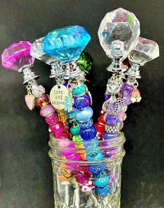 a jar filled with lots of different colored beads