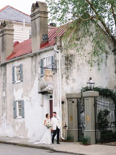 a bride and groom standing in front of an old building