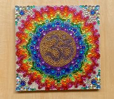 an art work made out of beads and other things in the shape of a circle