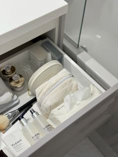 an open drawer in a bathroom filled with personal care items