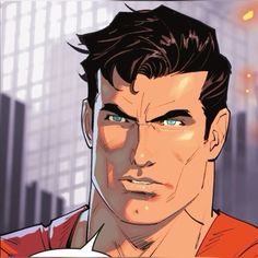 a close up of a person wearing a red shirt and blue eyes with buildings in the background