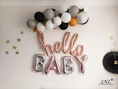 balloons that say hello baby are hanging on the wall