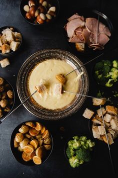 a table topped with bowls filled with different types of food and skewers on top of them