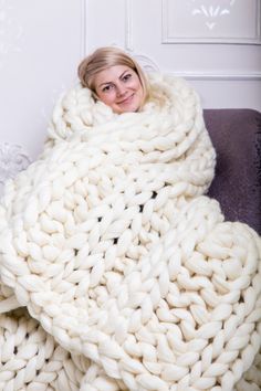 a woman wrapped up in a giant chunky blanket