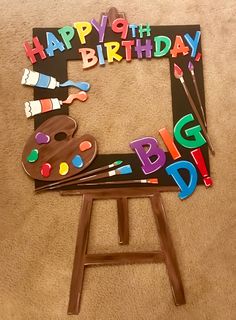 the birthday card is made to look like an easel with paint and letters on it