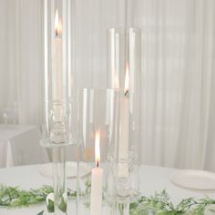 candles are sitting in glass vases on a table