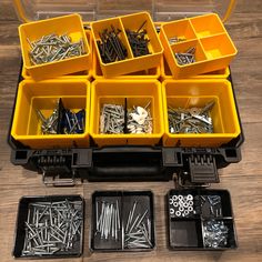 there are many different types of screws and nails in the box on the table