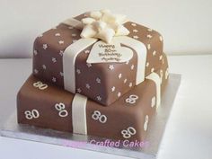 two brown and white birthday cakes sitting on top of each other