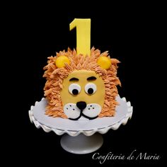 a lion cake with the number one on it's face is sitting on a plate