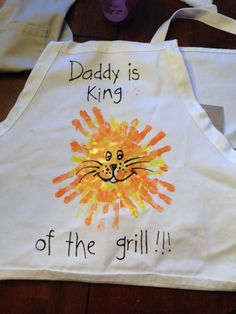 a child's apron with an image of a lion painted on it and the words daddy is king of the grill