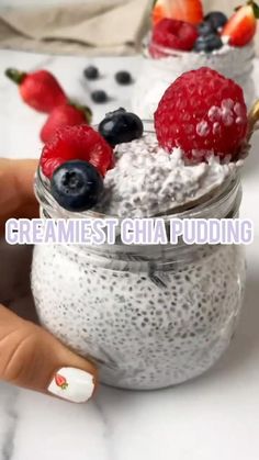 a person holding a spoon with some fruit on top of it in a jar and the words creamiest chia pudding