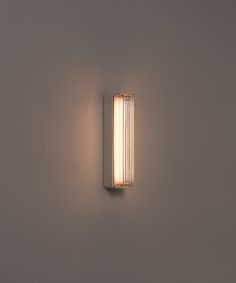 a light that is on the side of a wall in a room with grey walls