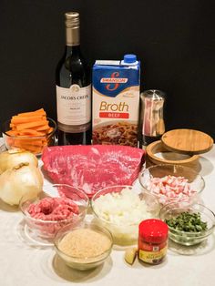 an assortment of ingredients on a table including meats, cheese and other foodstuffs