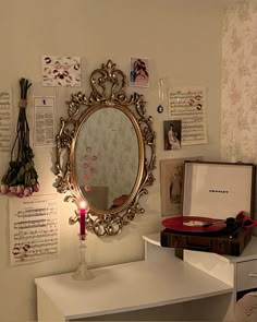 a mirror on the wall above a table with a candle and other items around it