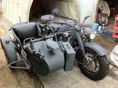 two motorcycles parked next to each other in front of a tent with tarps on it