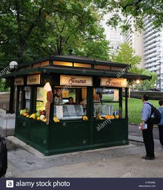 an outdoor kiosk with fruit on display in the park