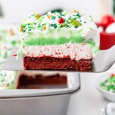 a piece of cake with green, white and red frosting on a spatula