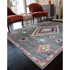 a living room area with two chairs and a rug on the floor in front of a fireplace