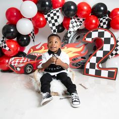 a young boy sitting on top of a white chair in front of balloons and numbers