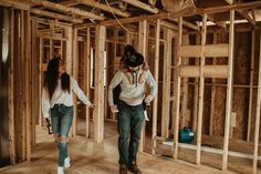 two people walking through a house under construction