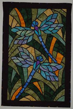 a stained glass window with dragonflies on it