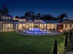 a large house with a swimming pool in the middle of it's yard at night