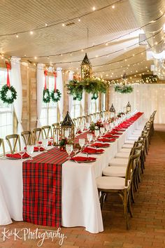 a dining room set up for christmas with plaid tablecloths and wreaths on the windows