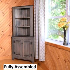 a wooden cabinet sitting next to a window