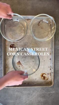 two hands are reaching for some food in a glass dish on a tray with the words mexican street corn casseroles