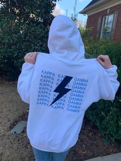 the back of a person wearing a white hoodie with blue lightning bolt on it