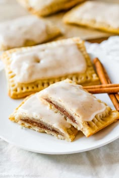 some food is sitting on a plate with cinnamon sticks in front of it and the rest of the sandwich has been cut into smaller pieces