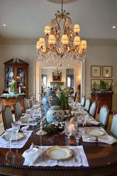 the dining room table is set with place settings for six people and there are chandeliers hanging from the ceiling