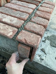 someone is placing bricks on the side of a building