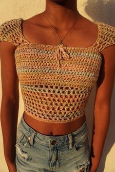 a close up of a person wearing shorts and a top with crochet on it