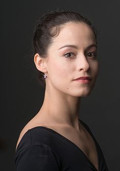 a woman in a black top is posing for a photo with her hand on her hip