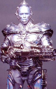 a man in silver armor holding a large metal object on top of his head and chest