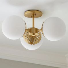 a ceiling light with three white balls hanging from it's center and two round lights on each side