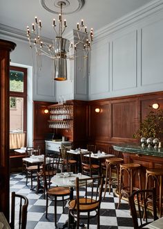 an empty restaurant with checkered floor and chandelier