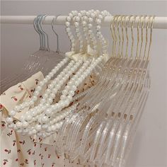 some white beads are hanging on a rack