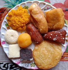 a plate full of assorted pastries and desserts on a floral table cloth