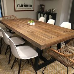 a wooden table with white chairs around it