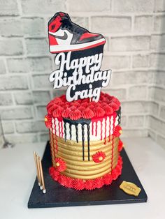 a birthday cake decorated with red, white and black icing