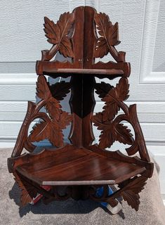 a wooden shelf sitting on top of a carpeted floor next to a white door