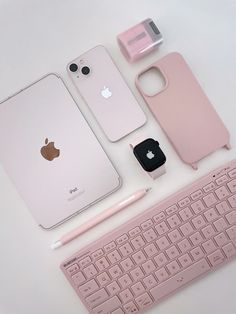 an apple phone, keyboard and other electronics on a white surface with a pink key board