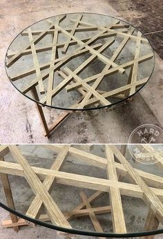 a round glass table with wooden sticks on the top and bottom, sitting on concrete flooring